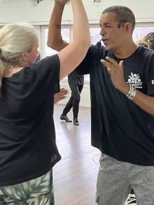 Rueda de Casino instructor demonstrating a partner move in a dance studio during a Cuban salsa class